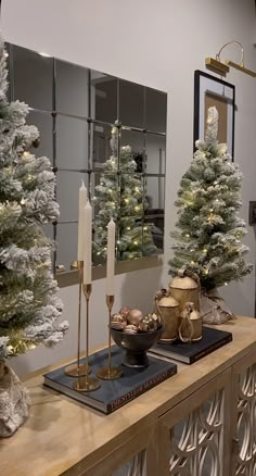 a table with candles and christmas trees in the corner, on which is a mirror