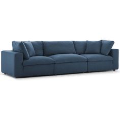 a blue couch with pillows on the back and arms, in front of a white background