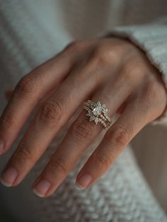 a woman's hand wearing a gold ring with three small diamonds on the band