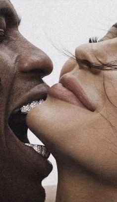 two people with their mouths open and one is biting into the other's mouth