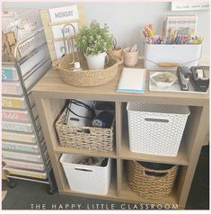 a wooden shelf with baskets and other items on it in front of a sign that says the happy little classroom