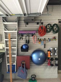 there is a gym room with exercise equipment on the wall and other items hanging from the ceiling