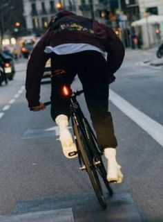 a bicyclist is riding down the street with his head turned to the left