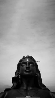 black and white photo of buddha statue with sky in the backgroung background