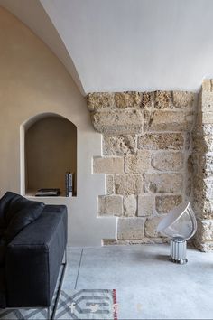 a living room filled with furniture and a stone wall