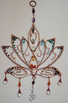 a decorative piece hanging from the ceiling with beads and charms on it's side