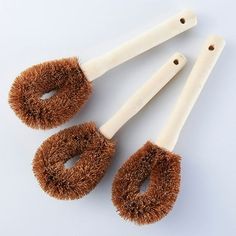 three brushes with brown bristles on top of each one and two white ones in the middle