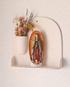 The Ceramic Wall Altar is the perfect way to add a meaningful accent to your home. Crafted from beautiful white terra cotta for longevity this will be an heirloom piece. The altar can be hung on the wall, filled with flowers in its built in vase, and hold your favorite religious artwork.At 10"x10"x4", this altar is the perfect size for displaying on a living room wall or near a prayer area. We pray that this altar may hold precious items that inspire a sense of calmness in your heart and closene Diy Clay Altar, Paper Mache Altar, Clay Altar, Flower Altar, Ceramic Altar, Wall Altar, Class 2023, Mini Altar, Religious Artwork