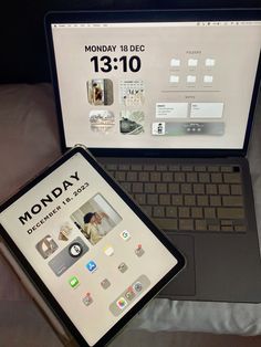 an open laptop computer sitting on top of a bed next to a monitor with the words monday written on it