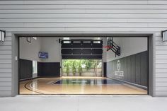 an indoor basketball court with the doors open