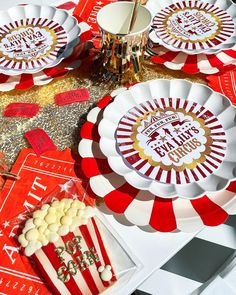 red and white plates with gold designs on them sitting on top of a checkered table cloth