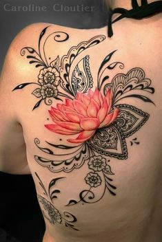 a woman's back with a flower tattoo on it