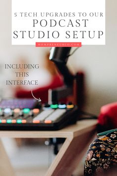 a desk with a microphone and headphones on it, in front of a red chair