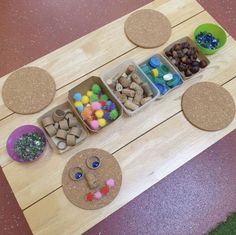 a wooden table topped with trays filled with different types of rocks and stones next to bowls