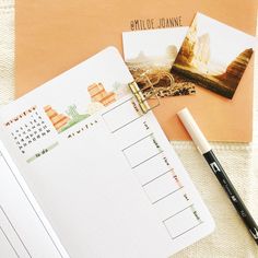 an open planner, pen and photos on a table