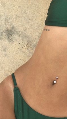 a woman's stomach with a tiny tattoo on it