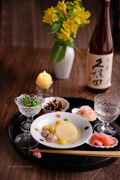 there is a plate with sushi and wine on the table