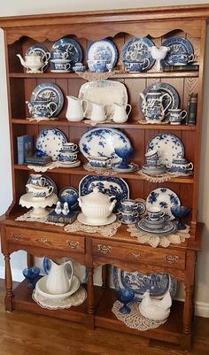 an old china cabinet is filled with blue and white dishes