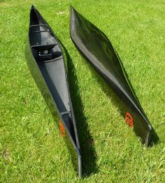 two canoes sitting in the grass near each other