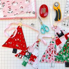 several pieces of fabric are laid out on a table with scissors and other crafting supplies