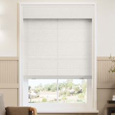 a living room with white blinds and a chair in front of the window that is closed