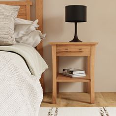 a bedroom with a bed, night stand and lamp on the nightstand next to it