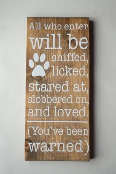 a wooden sign with a dog's paw on it