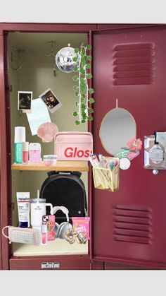 a red locker filled with lots of items next to a mirror and potted plant