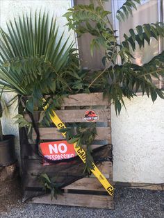 a wooden crate with plants in it and a no trespassing sign on the side