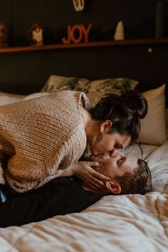 a man and woman laying in bed with their heads on each other's shoulders