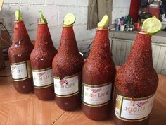 six bottles of hot sauce sitting on top of a wooden table