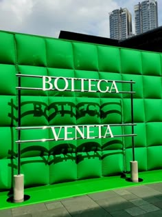 a green wall with the words bottega and veneta written on it