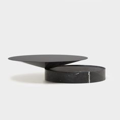 two black tables sitting side by side on top of each other, one with an upside down table