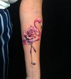 a flamingo with a rose tattoo on its arm