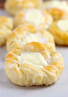 several pastries with white icing are lined up on a table