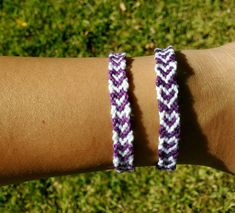 two purple and white bracelets on someone's arm