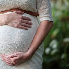 a pregnant woman is holding her stomach