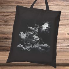 a black and white photo of a man on a horse in the clouds tote bag