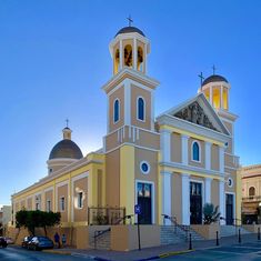 an old church with two steeples and a bell tower on the top is lit up at night