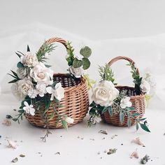 three wicker baskets with white flowers and greenery