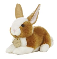 a brown and white stuffed rabbit with a tag on it's ear sitting down