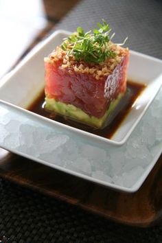 a plate with some food on it and sauce in the bowl next to it,