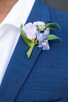 a man in a blue suit with a flower on his lapel