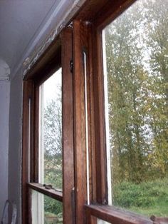 an open window in the corner of a room with wood trimmings on it