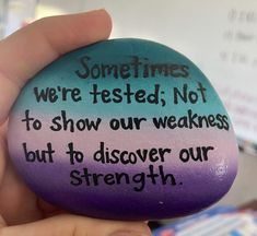 someone is holding a rock that says sometimes we're tested not to show our weakness but to discovery our strength