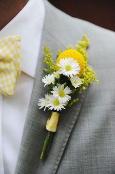 a man wearing a suit and bow tie with flowers in his lapel flower bouquet