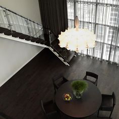 an overhead view of a dining room table with chairs and a vase filled with flowers