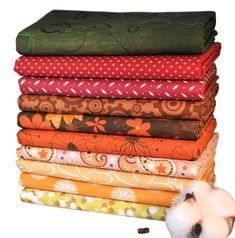 a pile of different colored fabrics next to a cotton ball