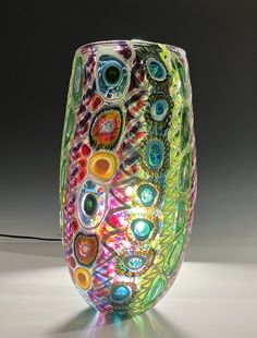 a colorful glass vase sitting on top of a table