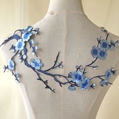 the back of a mannequin with blue flowers on it's neckline